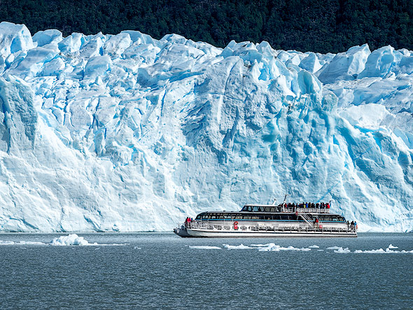 Tourist boat in front a this stunning glacier wall